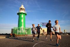 Runners with the South Mole Lighthouse